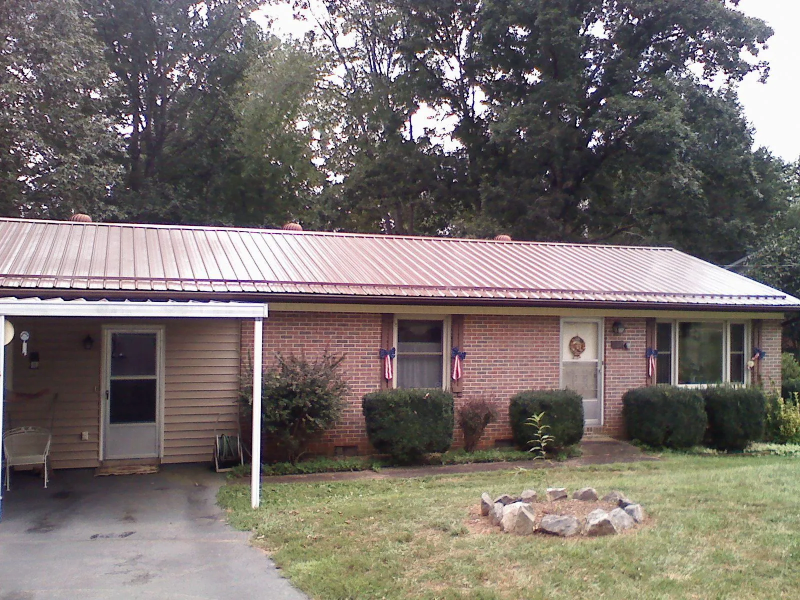 Bronze metal roof and carport on a brick ranch home — Roof Repair work by our crew in Ocklawaha