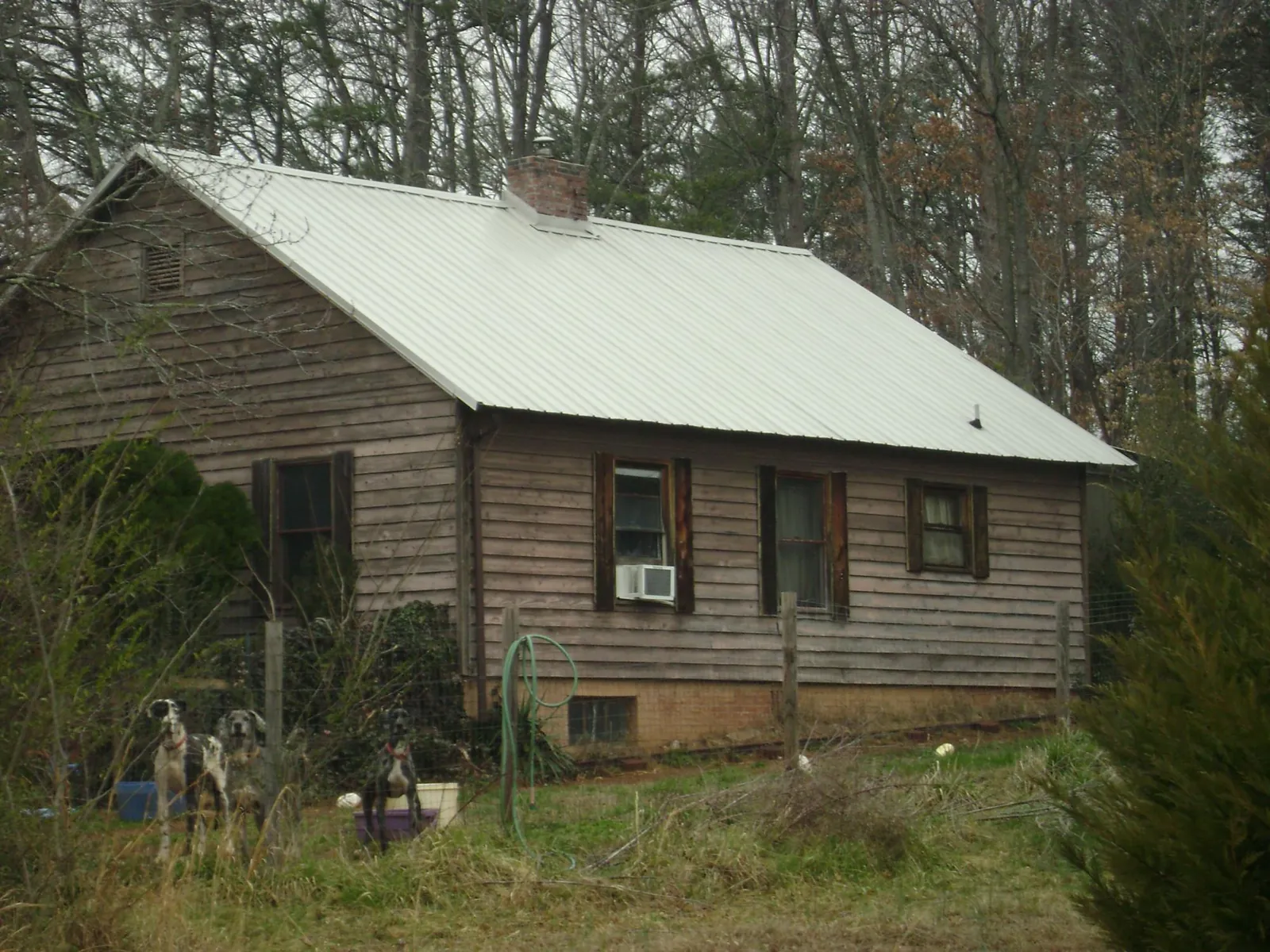 White metal roof on an old wood sided farmhouse, from a Metal Roof Installation job in Ocklawaha